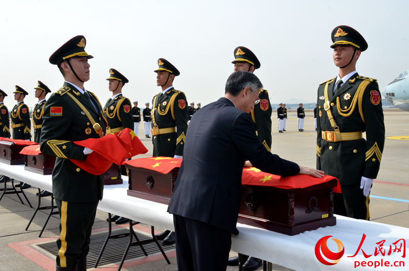 中國駐韓國大使邱國洪為中國人民志愿軍烈士遺骸棺槨覆蓋國旗。夏雪 攝